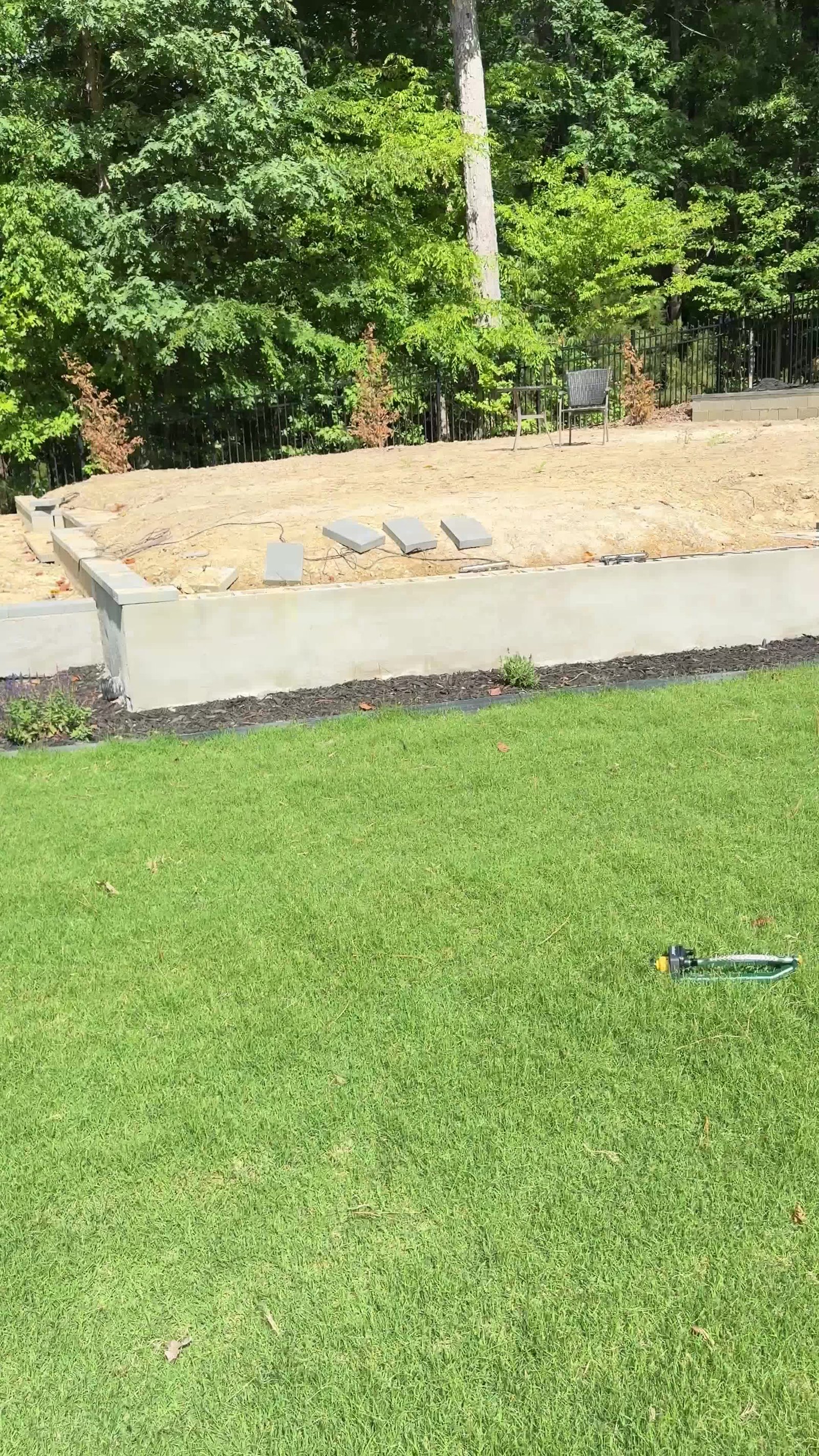 Concrete retaining wall with regraded yard and new sod